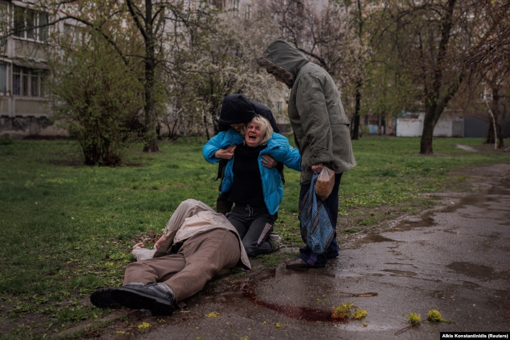 E ndihmuar nga partneri i saj, Yevgeniy Vlasenko, dhe nëna e saj, Lyubov, Yana Bachek shihet duke qarë mbi trupin e babait të saj, Victor Gubarev, i cili është vrarë, teksa ka qenë duke shkuar për të blerë bukë në Harkiv të Ukrainës, Fotografia është bërë më 18 prill 2022. &nbsp; Alkis Konstantinidis, Reuters. &nbsp; &nbsp;