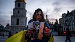 A woman holds a portrait of her husband, who was captured during the siege of the port city of Mariupol, during a rally in tribute to the defenders of Ukraine on Volunteer Day, in Kyiv on March 14.