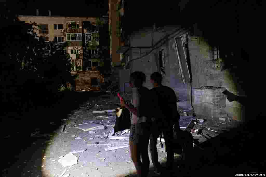 Local residents carry their belongings outside their damaged residential building. Ukraine&#39;s Interior Ministry said that 29 police officers and seven rescuers were injured in a second missile strike after responding to the initial attack on the city.&nbsp;
