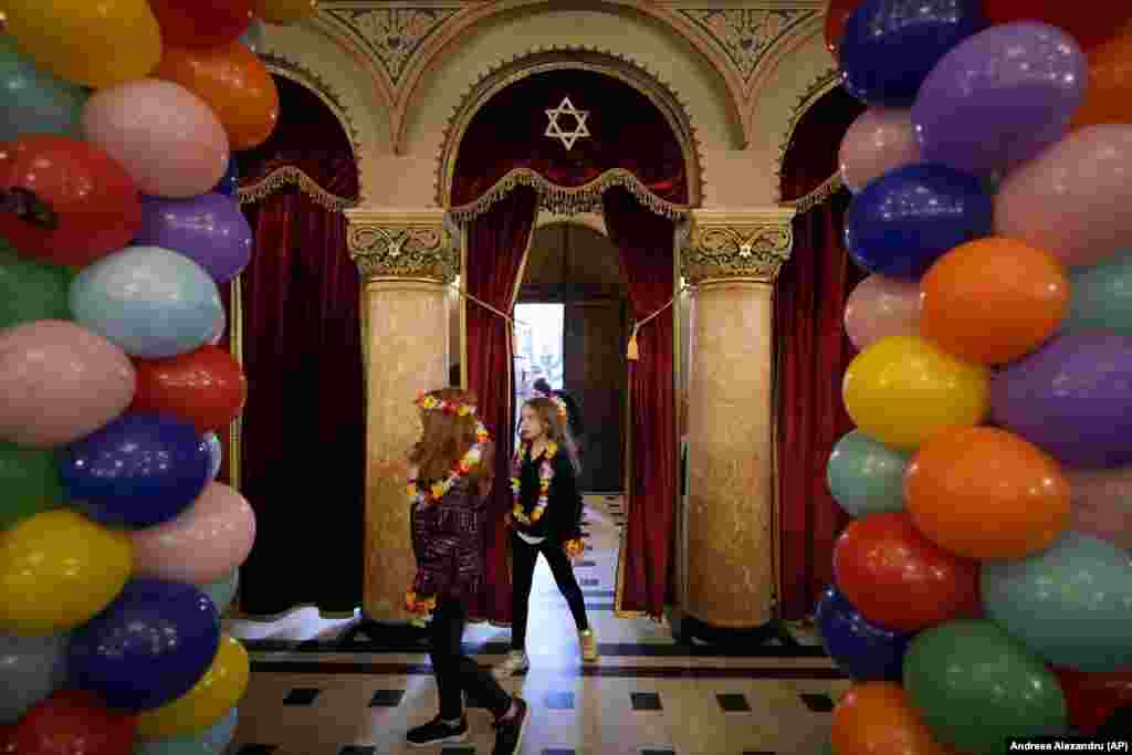 Children wearing colorful flower necklaces enter the Coral Temple synagogue as Romania&#39;s Jewish community celebrates Purim in Bucharest on March 6. The Jewish holiday of Purim commemorates the Jews&#39; salvation from genocide in ancient Persia, as recounted in the Book of Esther.