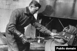 Lowell Smith arranging the storage area of his biplane. The pilots were not equipped with life jackets or parachutes due to weight and space restrictions.