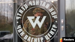 Жекеменшік әскери компанияның кеңсесі ресми түрде ашылғаннан кейін, "Вагнер орталығы" ғимаратынан шығып келе жатқан әскери киім киген адам. Санкт-Петербург, Ресей, 4 қараша, 2022 жыл.
