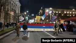 Pristalice ultradesničara u protestnoj šetnji u centru Beograda sa zastavom Srbije na kojoj piše "Kad se vojska na Kosovo vrati", 24. mart 2024.