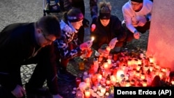 Mourners light candles outside the headquarters of Charles University in memory of the victims of the mass shooting in Prague.