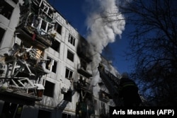 Пожарные тушат пожар в здании после взрывов в городе Чугуев на востоке Украины 24 февраля 2022 года