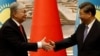 Глава Китая Си Цзиньпин (справа) и президент Казахстана Касым-Жомарт Токаев обмениваются рукопожатием во время церемонии подписания документов в Сиане, Китай, 17 мая 2023 года