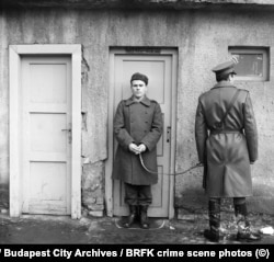 Задержанный стоит в очерченном мелом полукруге на месте предполагаемого преступления в Будапеште
