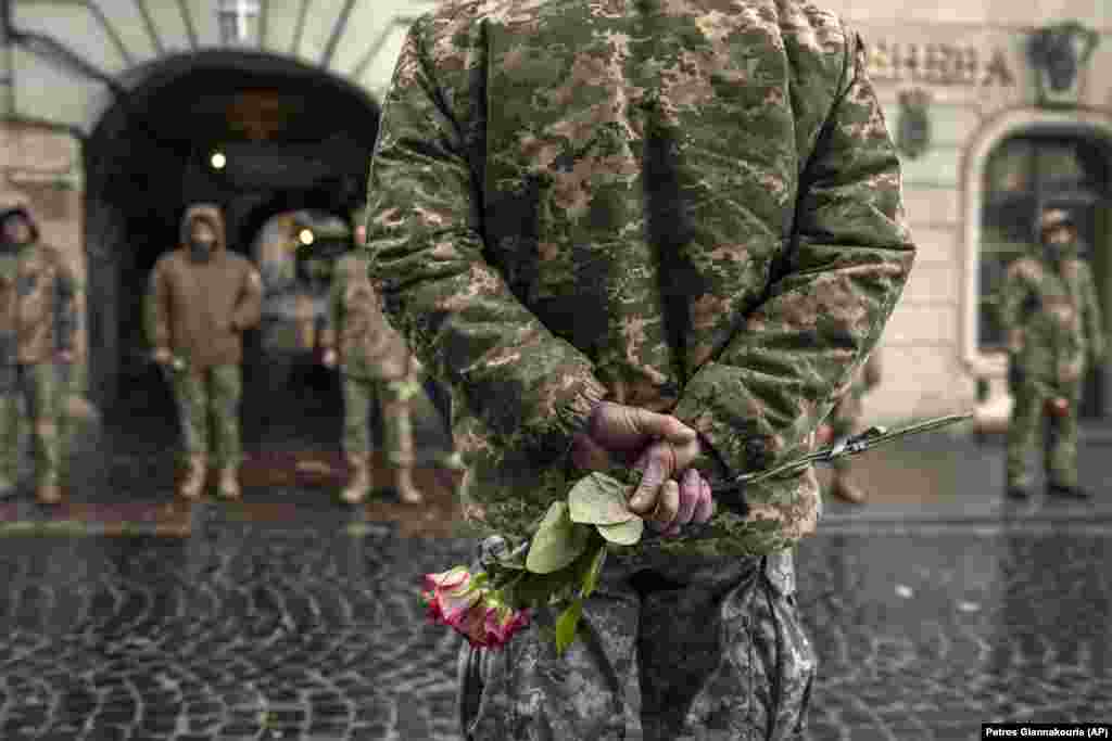 Soldiers hold roses at their commander&#39;s funeral outside the Holy Apostles Peter and Paul Church in Lviv in western Ukraine.&nbsp;