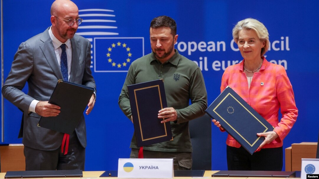 Președintele Consiliului European Charles Michel (stânga), președintele ucrainean Volodimir Zelenski și președintele Comisiei Europene Ursula von der Leyen, la ceremonia de semnare la Bruxelles, pe 27 iunie.