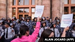 Демонстранты держат плакаты перед входом в Дом правительства во время митинга в Ереване. Армения, 21 сентября 2023 года