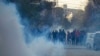 Supporters of Imran Khan's Pakistan Tehreek-e-Insaf (PTI) party run from tear gas while they protest against the alleged rigging of Pakistan's national election results, in Rawalpindi on February 11.