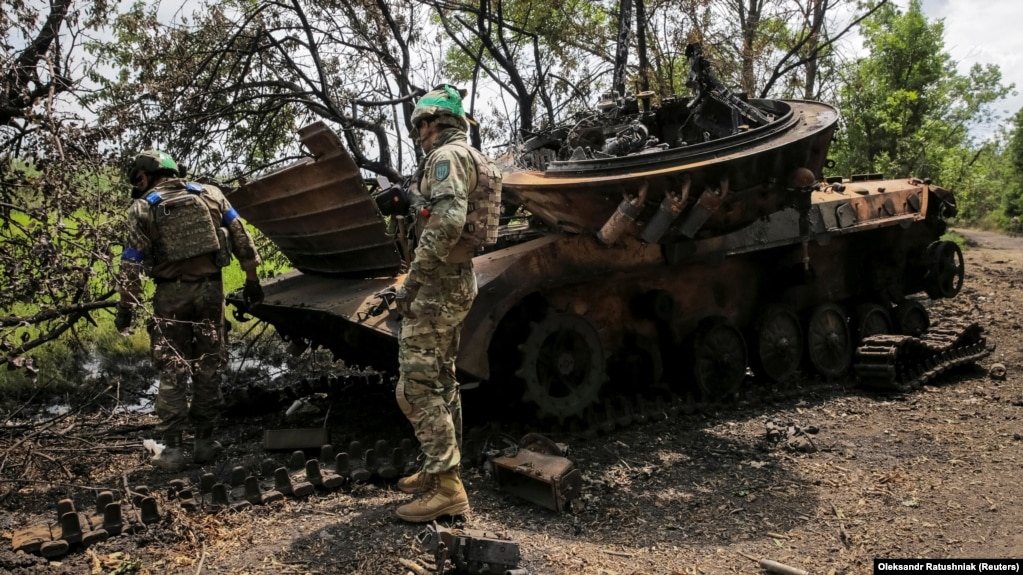 Украинские военнослужащие осматривают уничтоженную российскую БМП-2 в селе Сторожевое Донецкой области, освобожденном от российской армии, 14 июня 2023 года
