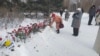 Стихийный мемориал в память о Навальном у памятника жертвам политрепрессий в Новосибирске. Памятник оцеплен – люди оставляют цветы возле ленты полиции