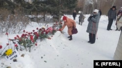 Стихийный мемориал в память о Навальном у памятника жертвам политрепрессий в Новосибирске. Памятник оцеплен – люди оставляют цветы возле ленты полиции