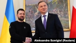 Президент Польши Анджей Дуда (справа) и президент Украины Владимир Зеленский обмениваются рукопожатием в Варшаве, 15 апреля 2023