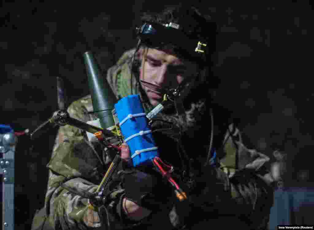 A Ukrainian soldier attaches a shell to a drone. As the use of drones intensifies, both sides are now engaging in electronic warfare to jam the other&#39;s devices, resulting in a notably high loss of drones. U.S. officials report that Ukraine&#39;s armed forces are losing an estimated 10,000 drones each month.