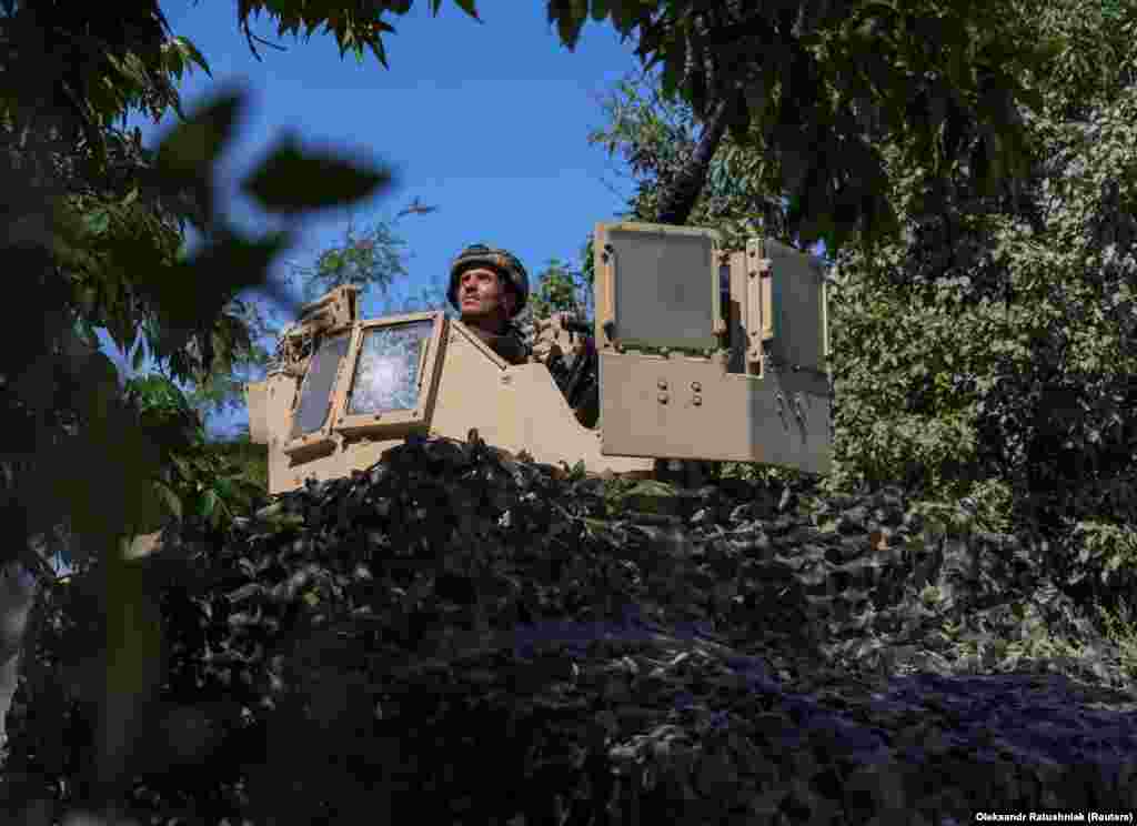 A camouflaged Ukrainian air-defense unit hidden among the trees keeps watch. &nbsp;