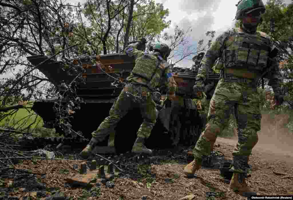 Українські військовослужбовці оглядають знищену російську БМП-2 у звільненому від армії РФ селі Сторожеве на Донеччині, 14 червня 2023 року