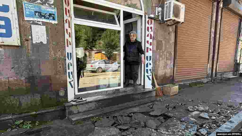 O femeie stă în ușa magazinului ei distrus din Alaverdi. Orașul nu are încă acces la apă potabilă, energie electrică sau gaz. &nbsp;