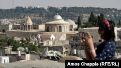 A woman takes a photo in Jerusalem with the city's Armenian quarter in the background. (See: Jerusalem Armenians Fear Shadowy Land Deal Marks 'Beginning Of The End')