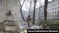 A Ukrainian soldier walks past residential buildings damaged by a Russian military strike in the frontline city of Bakhmut, Donetsk region, on April 21. 
