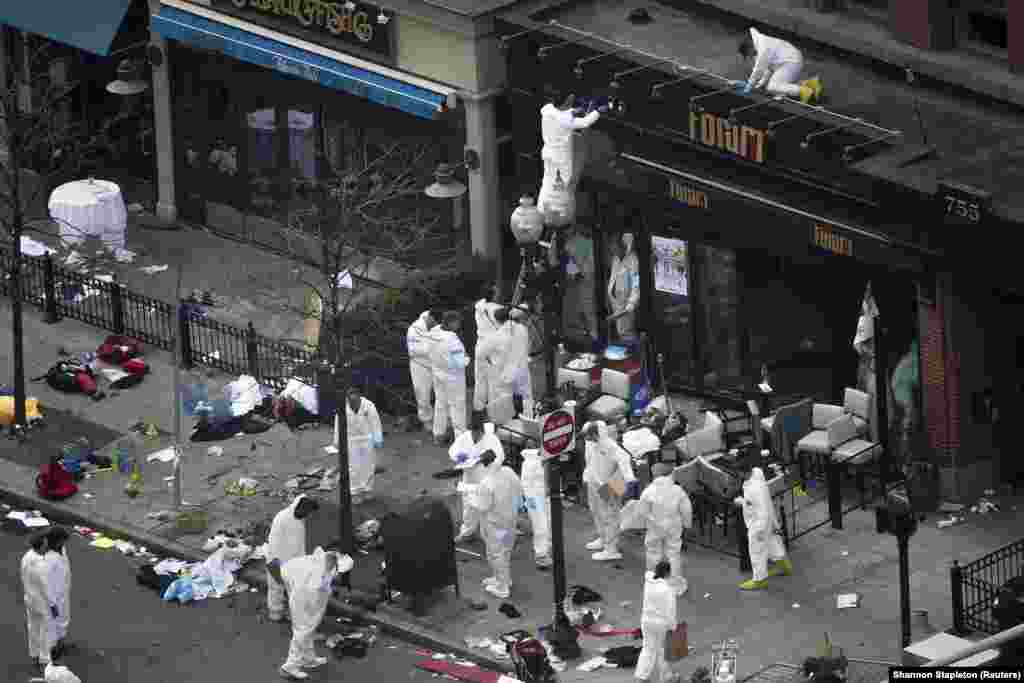 Zvaničnici zaštitnim odijelima istražuju mjesto prvog bombaškog napada na ulici Boylston 16. aprila 2013. godine.