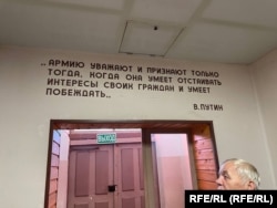 Виктор Приступа в сградата на военния музей ма фона на цитат на Владимир Путин, изписан на стената. Той гласи: "Армията е уважавана и призната само когато умее да защитава интересите на своите граждани и знае как да побеждава."