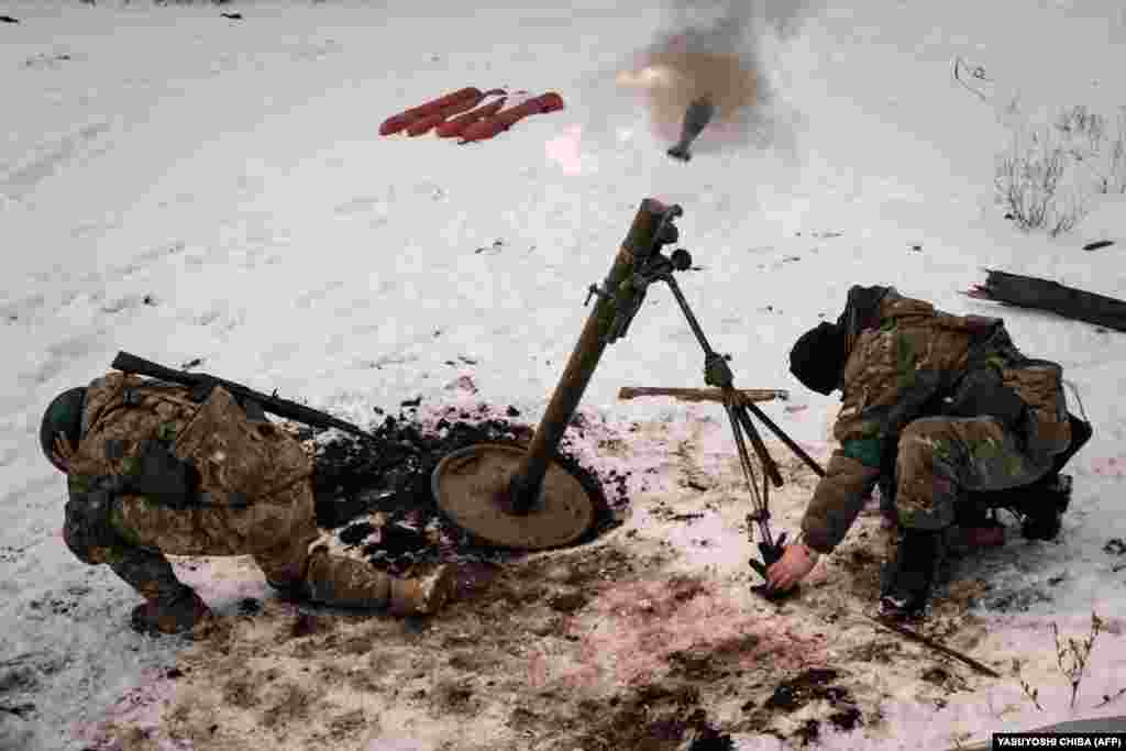 Mortarmen cup their ears as they launch a mortar toward Russian positions. As Moscow&#39;s forces close in on the shattered city, the leader of the Wagner mercenary group predicted that it could take weeks, if not months, for Bakhmut to fall.