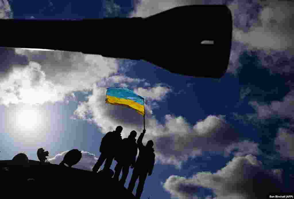 Ukrainian soldiers who are undergoing training at Bovington Camp, a British Army military base, wave a Ukrainian flag, in southwest England.