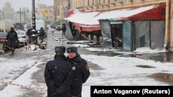 Police officers stand guard at the scene of an explosion in St. Petersburg that killed Russian military blogger Vladlen Tatarsky. 