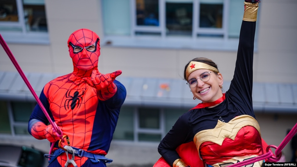 Dy vullnetarë nga Klubi Alpin Prishtina, të veshur me kostumet e superheronjve Spiderman dhe Superwoman.