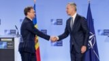 În 2025, R. Moldova va trece la o formă nouă de parteneriat cu Alianța Nord-Atlantică. În imagine: premierul moldovean, Dorin Recean (stânga) și secretarul general NATO, Jens Stoltenberg, strângându-și mâinile la un eveniment de presă de la Bruxelles, octombrie 2023. 
