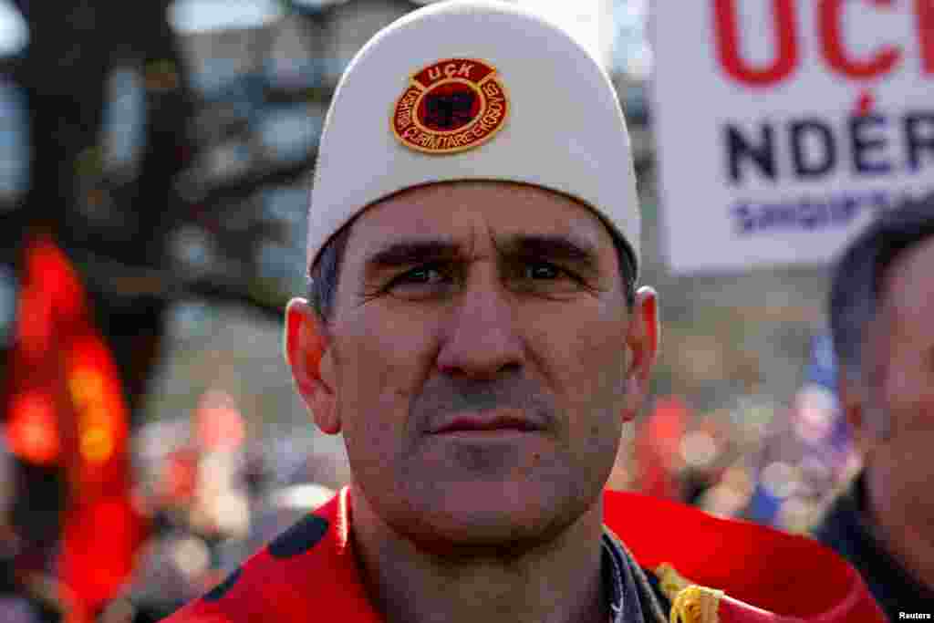 Një qytetar shqiptar mban një plis me emblemën e UÇK-së gjatë protestës.&nbsp;