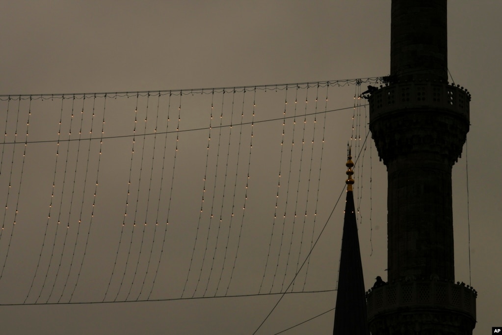Mjeshtrit e Mahyas duke punuar në instalimin e një mesazhi me drita në krye të njërës prej minareve të Xhamisë Sulejmani për muajin e Ramazanit në Stamboll. Mahya është tradita unike turke e vargjeve, mesazheve dhe motiveve fetare midis minareve.