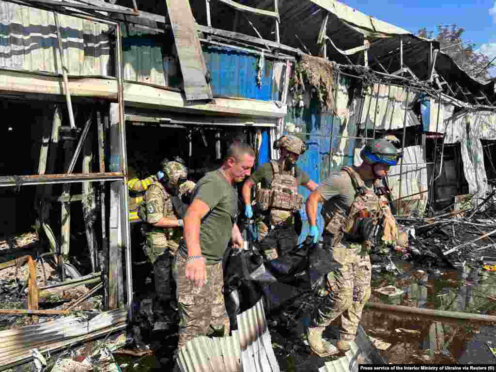 Рятувальники виносять тіла загиблих через удар по ринку в Костянтинівці Донецької області, 6 вересня 2023 року