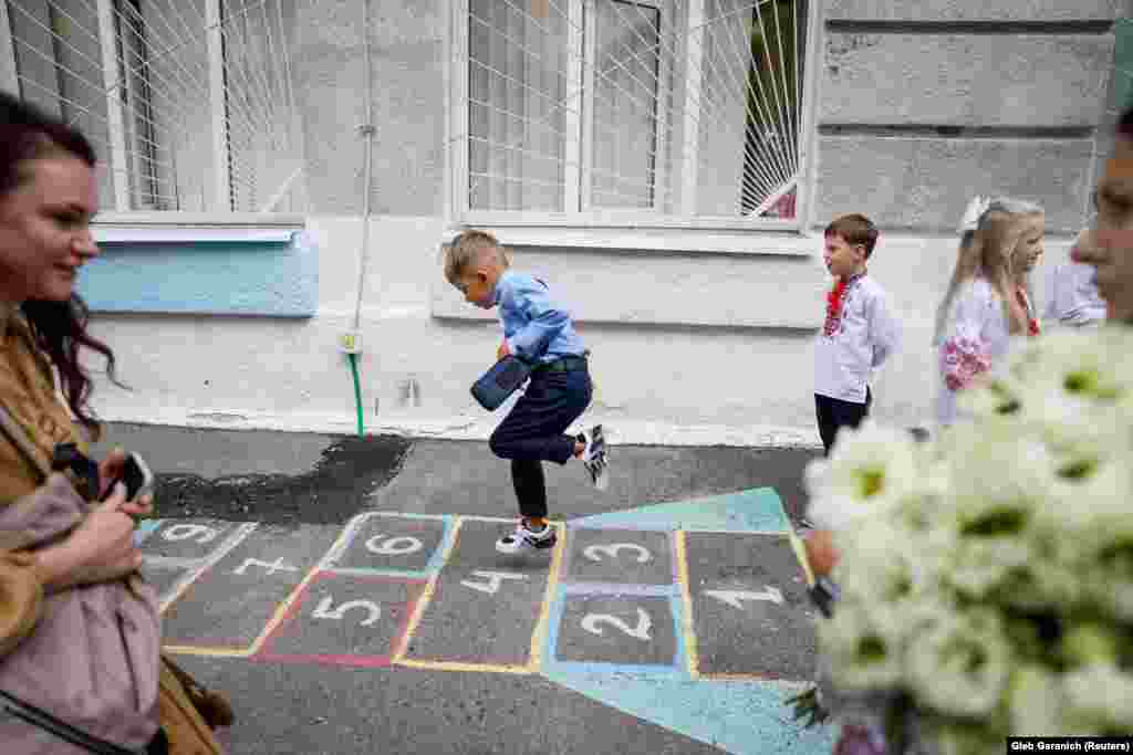 Első osztályosok játszanak az iskolaudvaron a tanévnyitó után Kijevben