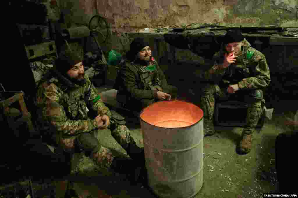 Українські мінометники гріються в укритті біля вогнища. Бахмут, 16 лютого 2023 року