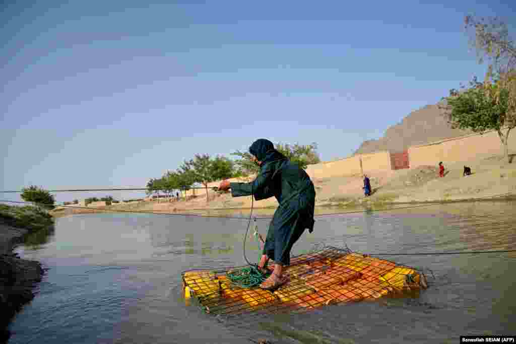An Afghan youth uses a raft made of plastic jugs to cross a canal in the Arghandab district of Kandahar Province.