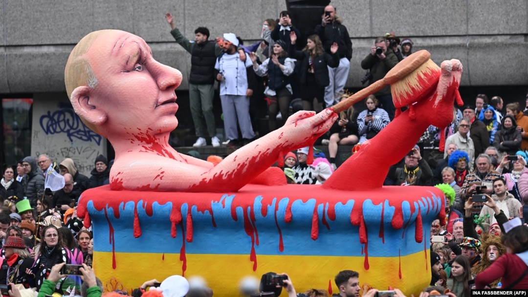 Un car alegoric de carnaval îl înfățișează pe președintele Rusiei, Vladimir Putin, făcând o baie de sânge într-o cadă galben-albastră, la festivalul ținut de „Lunea Trandafirilor”, Duesseldorf, Germania, 20 februarie 2023.