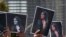 Protesters hold up photos of Mahsa Amini at a protest following her death in police custody.