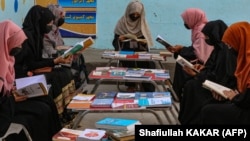 Afghan girls read at a library in Jalalabad. The Islamist group has barred girls from attending school past the sixth grade and banned women from going to university.