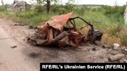 Згоріла машина, поруч – два тіла російських військових, від яких вже лишилися самі скелети. Времівка, 17 червня 2023 року