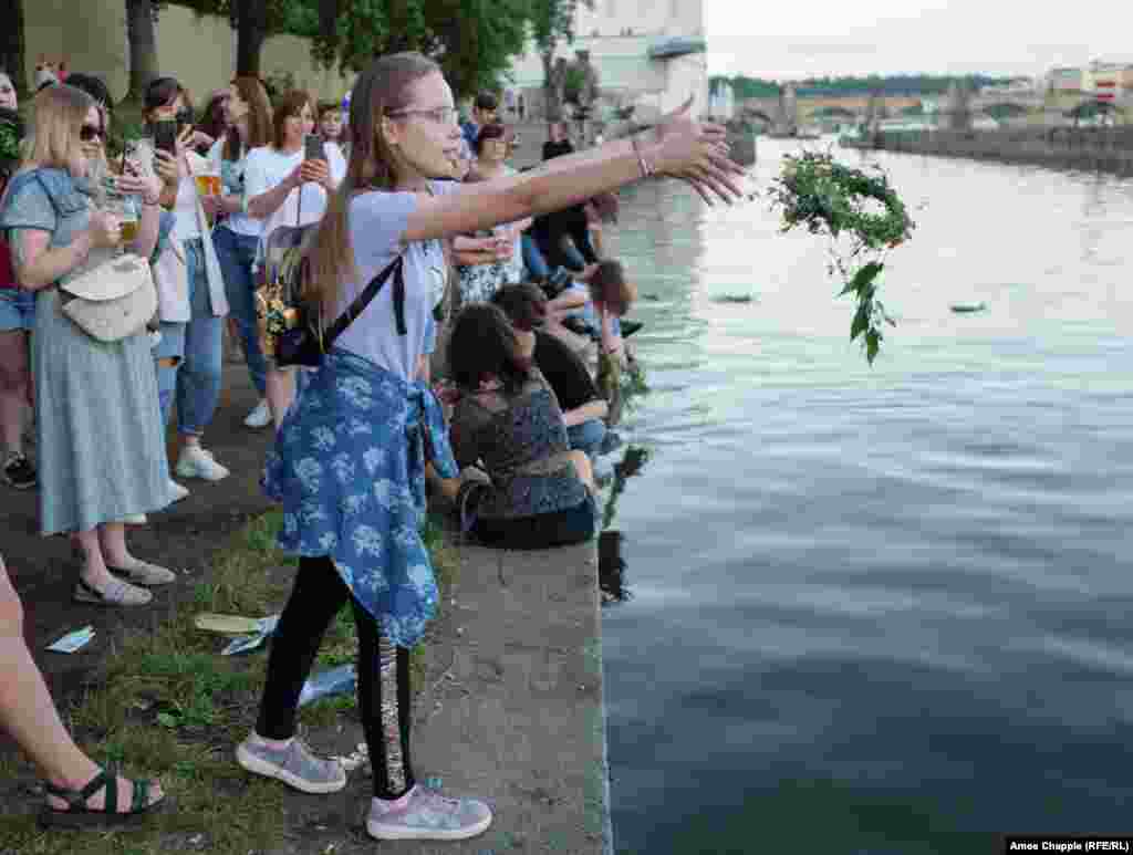 A girl throws her wreath into the Vltava River. Tradition holds that wreaths cast into a waterway by unmarried girls will float in the direction of their future husbands.