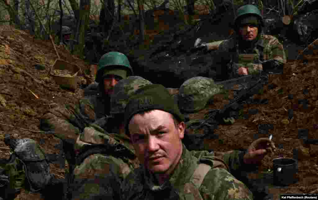 Ukrainian servicemen wait in a trench after incoming fire near the frontline town of Bakhmut.