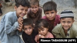 Afghan children pose for a photo at an Afghan refugee camp in Karachi on September 21.