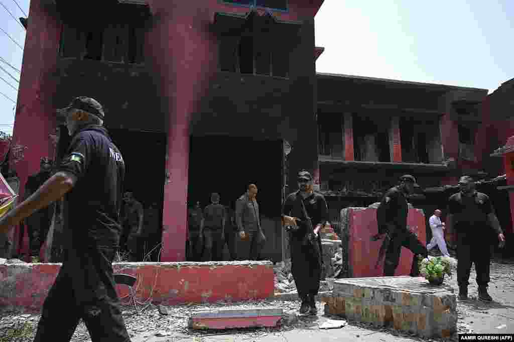 Police officials inspect a damaged Salvation Army church in Jaranwala on August 17. Officials said more than 120 people were arrested overnight.