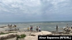 Каспий теңізі жағалауында тұрған адамдар. Маңғыстау, Ақтау қаласы. 15 маусым, 2023 жыл (Азаттық архивіндегі фото)