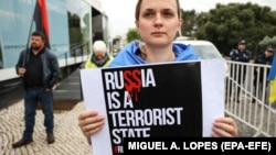Жінка з плакатом «Росія – терористична держава» на акції у столиці Португалії, Лісабон, 21 квітня 2023 року