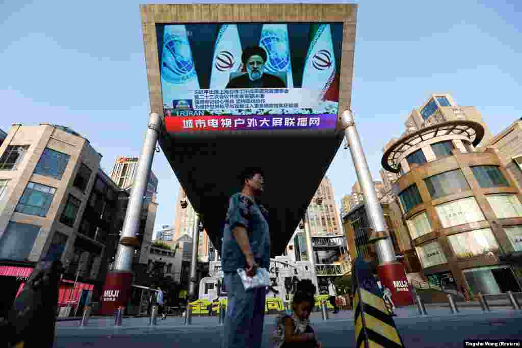 A giant screen broadcasts news footage of Iranian President Ebrahim Raisi attending via video link a meeting of the Shanghai Cooperation Organization n Beijing.