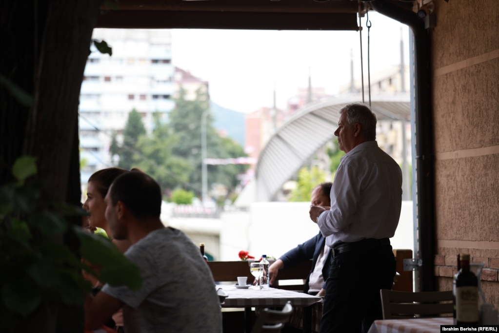 Kamerieri Agron Berisha duke u shërbyer të klientëve në restorantin “Ura”.